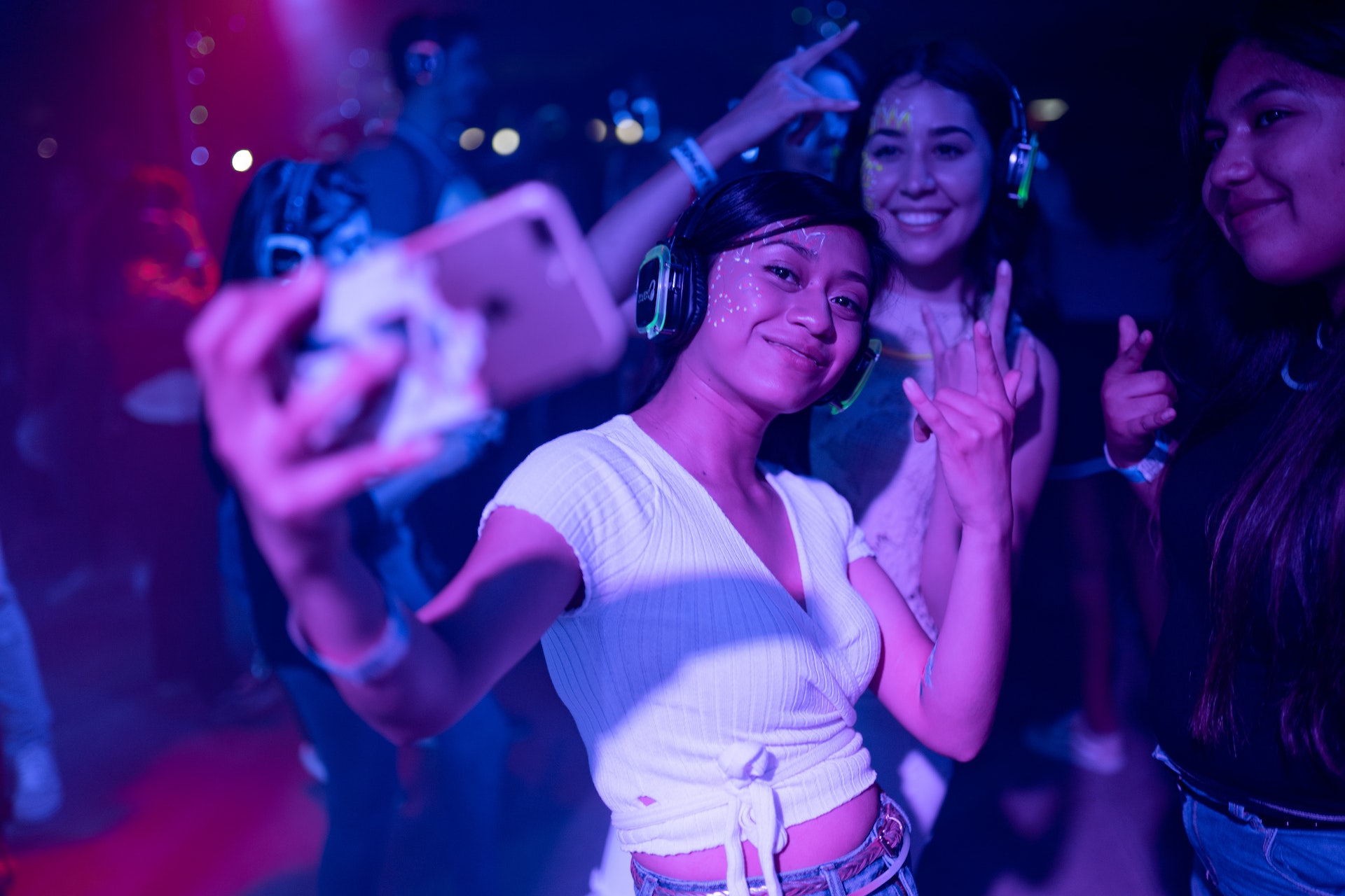 Women wearing silent disco headphones at a party