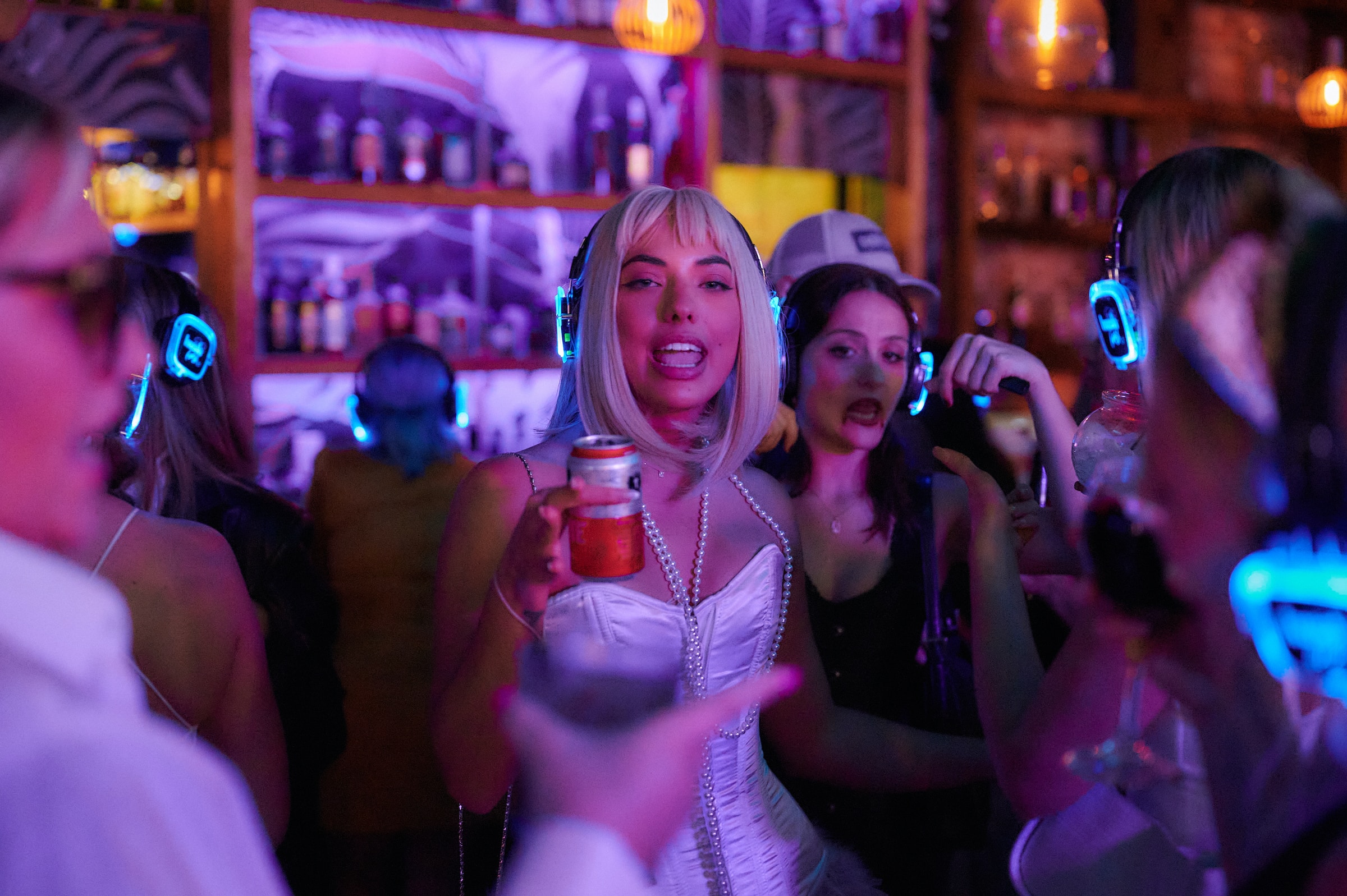 Party girls wearing silent disco headphones in a bar