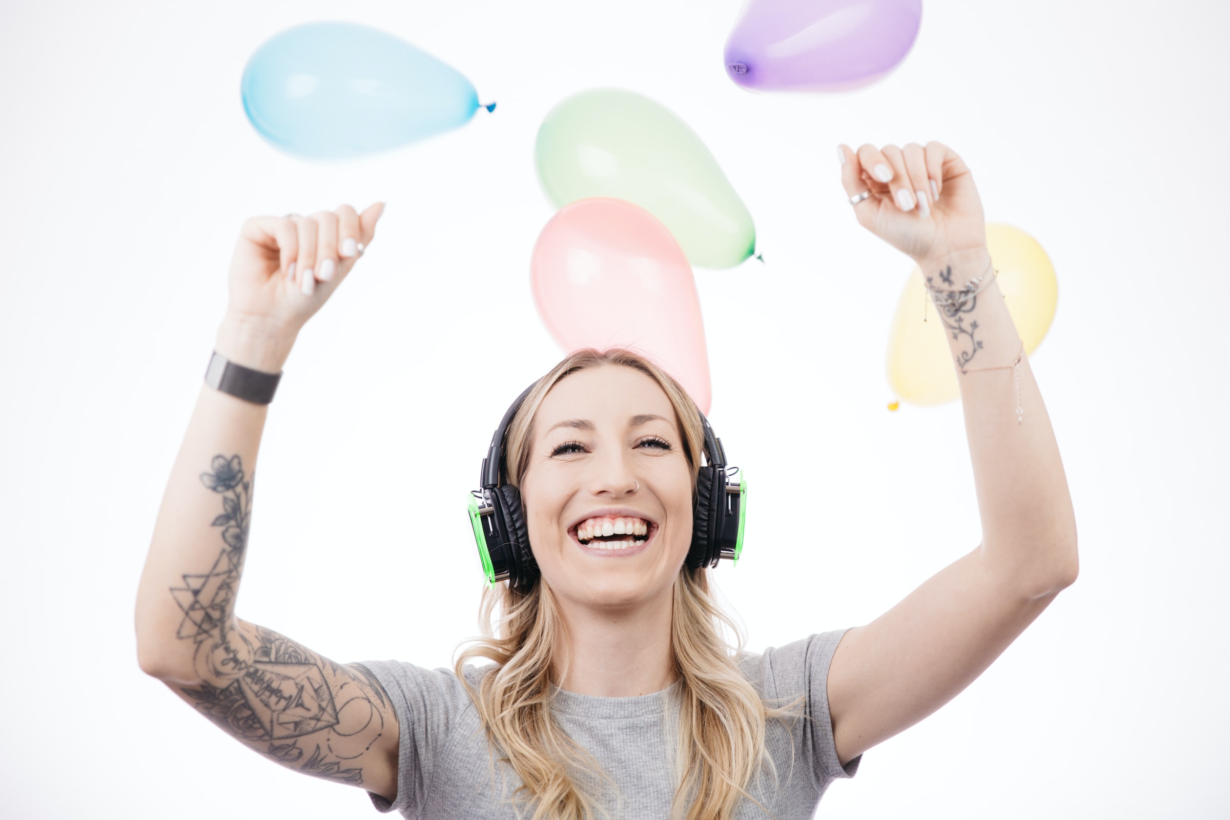 Young woman with tattoos wearing silent disco headphones at a party